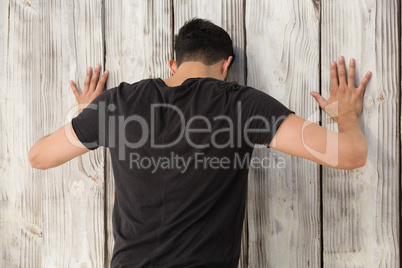 Man leaning on wooden wall