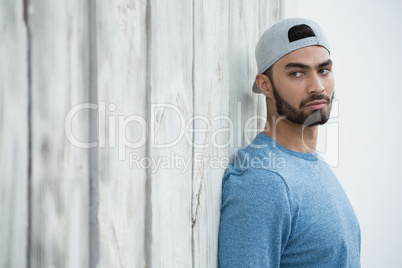 Man leaning on wooden wall