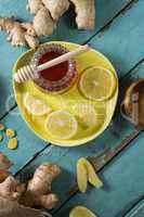 Lemon and ginger with honey jar on wooden table