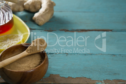 Ginger powder in wooden bowl on table