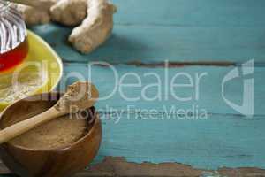Ginger powder in wooden bowl on table