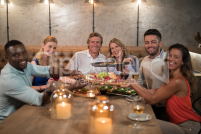 Friends passing food to each other while dining