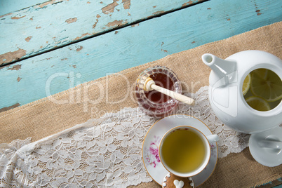 High angle view of honey by ginger tea in cup on burlap