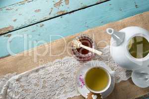 High angle view of honey by ginger tea in cup on burlap