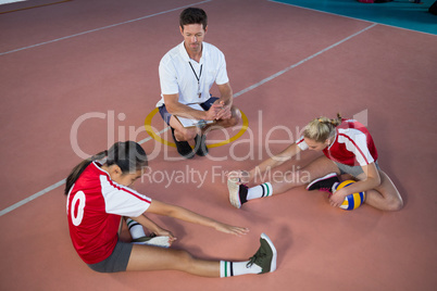 Volleyball players performing stretching exercise