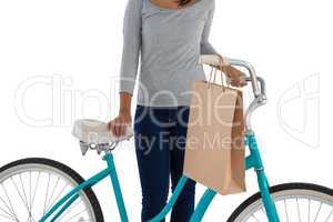 Mid section of woman with paper bag and bicycle