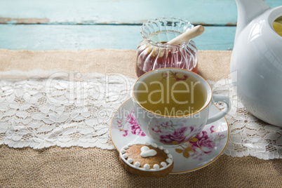 Ginger tea in cup by honey on burlap