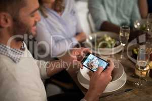 Man taking photo of meal with mobile phone