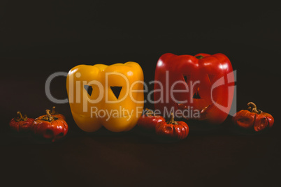 Carved bell peppers with small pumpkins over white background