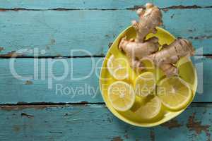Lemon and ginger in yellow plate on table