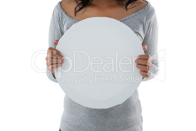 Mid section of woman holding circle shaped placard