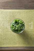 Fresh kale leaves in glass on table