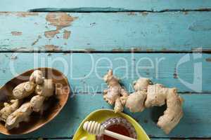 Ginger with honey jar on wooden table