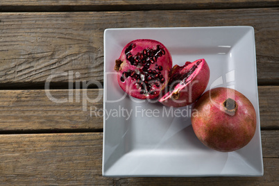 Pomegranates in a plate on a wooden table