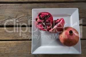 Pomegranates in a plate on a wooden table