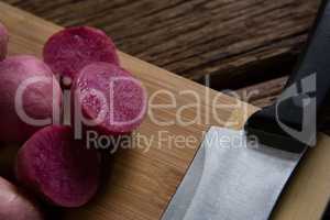 Sweet potatoes and knife on a chopping board