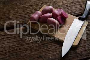 Sweet potatoes and knife on a chopping board