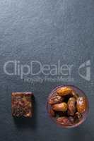 Overhead view of dates fruits in bowl on slate