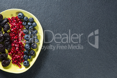 Overhead view of various fruits in plate on slate