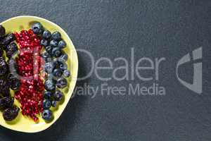 Overhead view of various fruits in plate on slate