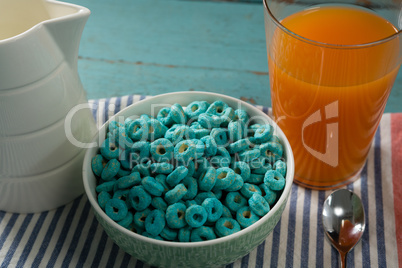 Cereal rings and orange juice on napkin cloth