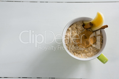 Cup of oats with peanut butter and cinnamon sticks