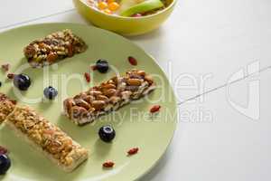 Granola bars in plate on white background