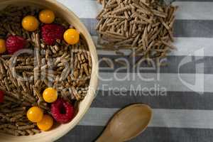 Bowl of cereal bran stick with golden berries and raspberries