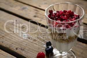 Cup of yogurt muesli and pomegranates for breakfast