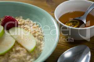 Fruit cereal and honey on wooden table