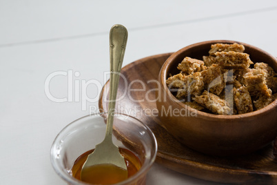 Granola bar and honey on white background