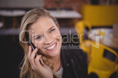 Portrait of smiling young pretty woman listening to smartphone