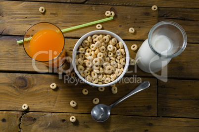 Cereal rings, orange juice and milk on wooden table