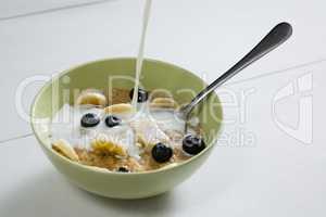Pouring milk into bowl of breakfast cereal
