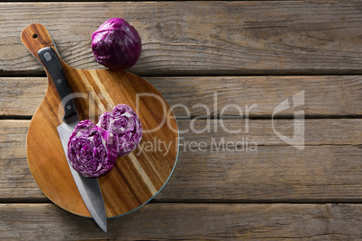 Red cabbage with knife on chopping board