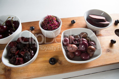 Olives with beetroot slices and various fruits in bowls