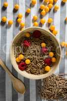 Bowl of cereal bran stick with golden berries and raspberries