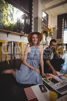 Portrait of smiling young female professional sitting with male colleague