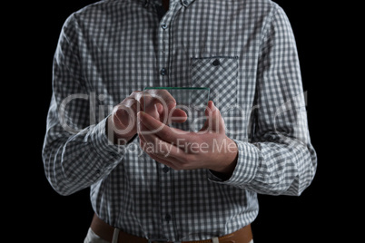 Mid-section of man using glass mobile phone