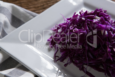 Chopped red cabbage in plate on wooden table