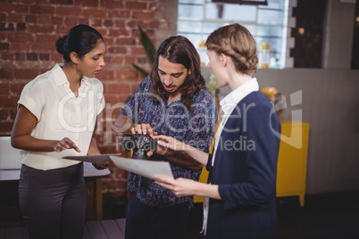 Young man showing camera to female colleagues