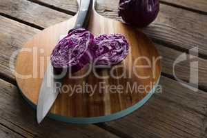 Red cabbage with knife on chopping board