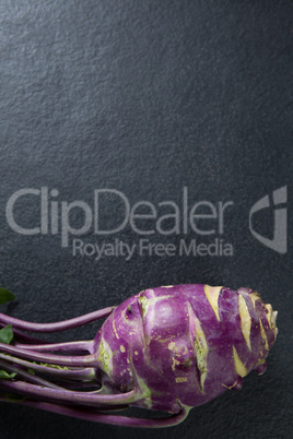 Overhead view of purple root vegetable on slate