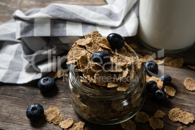 Jar filled with wheat flakes and blue berries