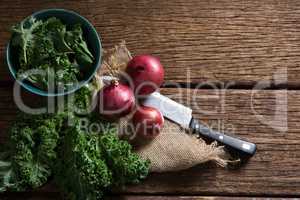 Mustard greens and onions on wooden table