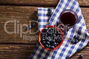 Bowl of blueberries and juice on wooden table