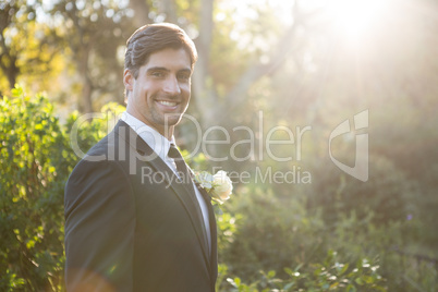 Portrait of handsome bride standing by plants