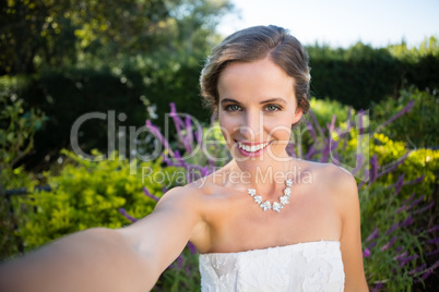 Portrait of smiling beautiful bride standing in yard