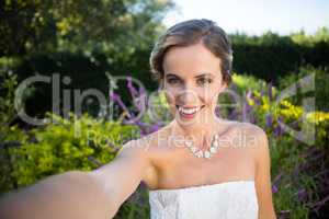 Portrait of smiling beautiful bride standing in yard