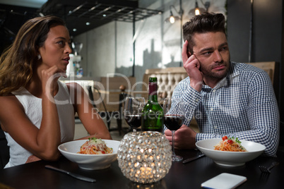 Man ignoring woman while dining